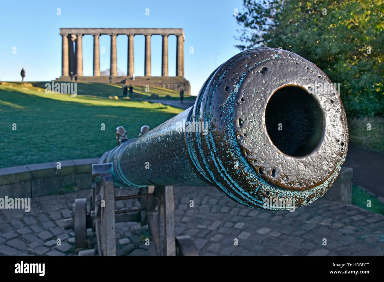 Barrel of cannon captured in a Burma war unfinished Scottish National Monument of Scotland beyond all located on the top of Carlton Hill Edinburgh uk Stock Photo