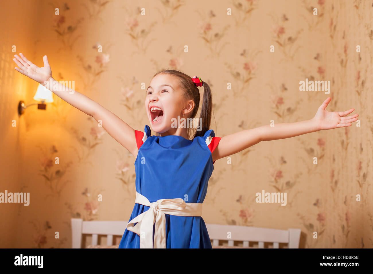 Happy little girl hands up Stock Photo - Alamy