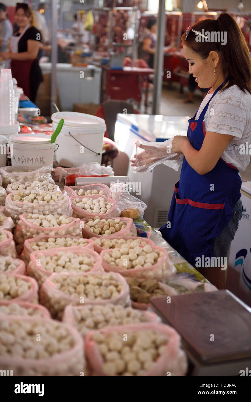 Young woman selling Kumis cheese balls at Shymkent Central Market Kazakhstan Stock Photo