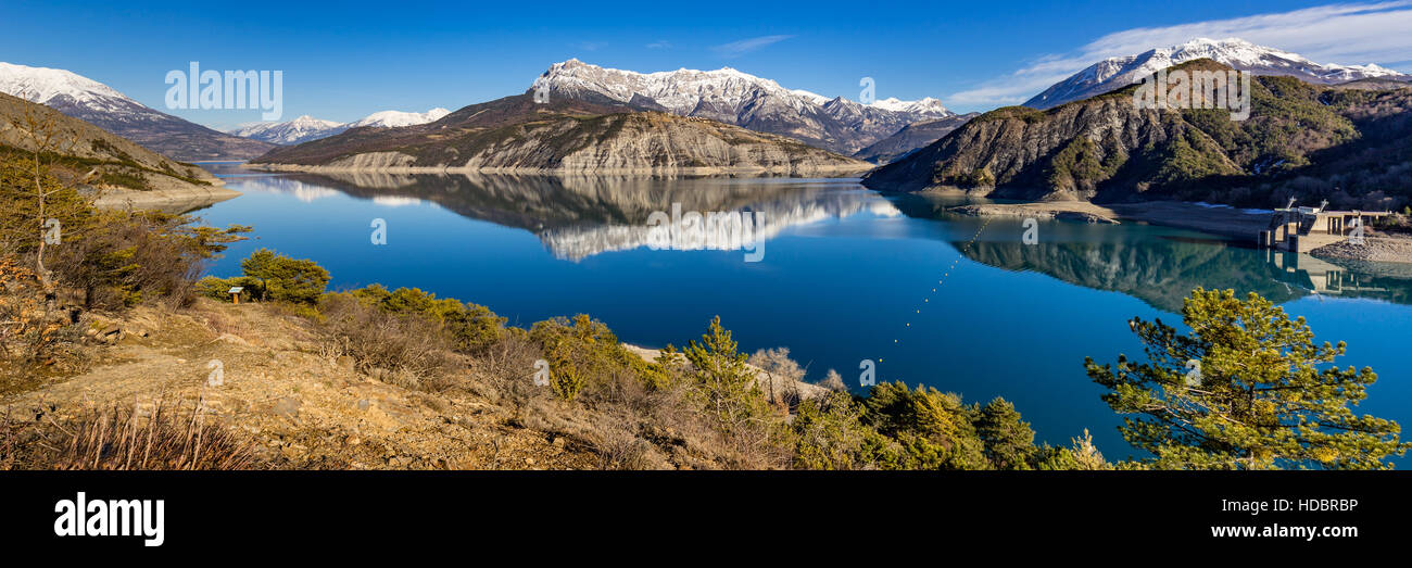 Panoramic view from hiking trail of Serre Poncon Lake in Winter with snow covered mountains. Le Rousset, Hautes Alpes, Southern French Alps, France Stock Photo