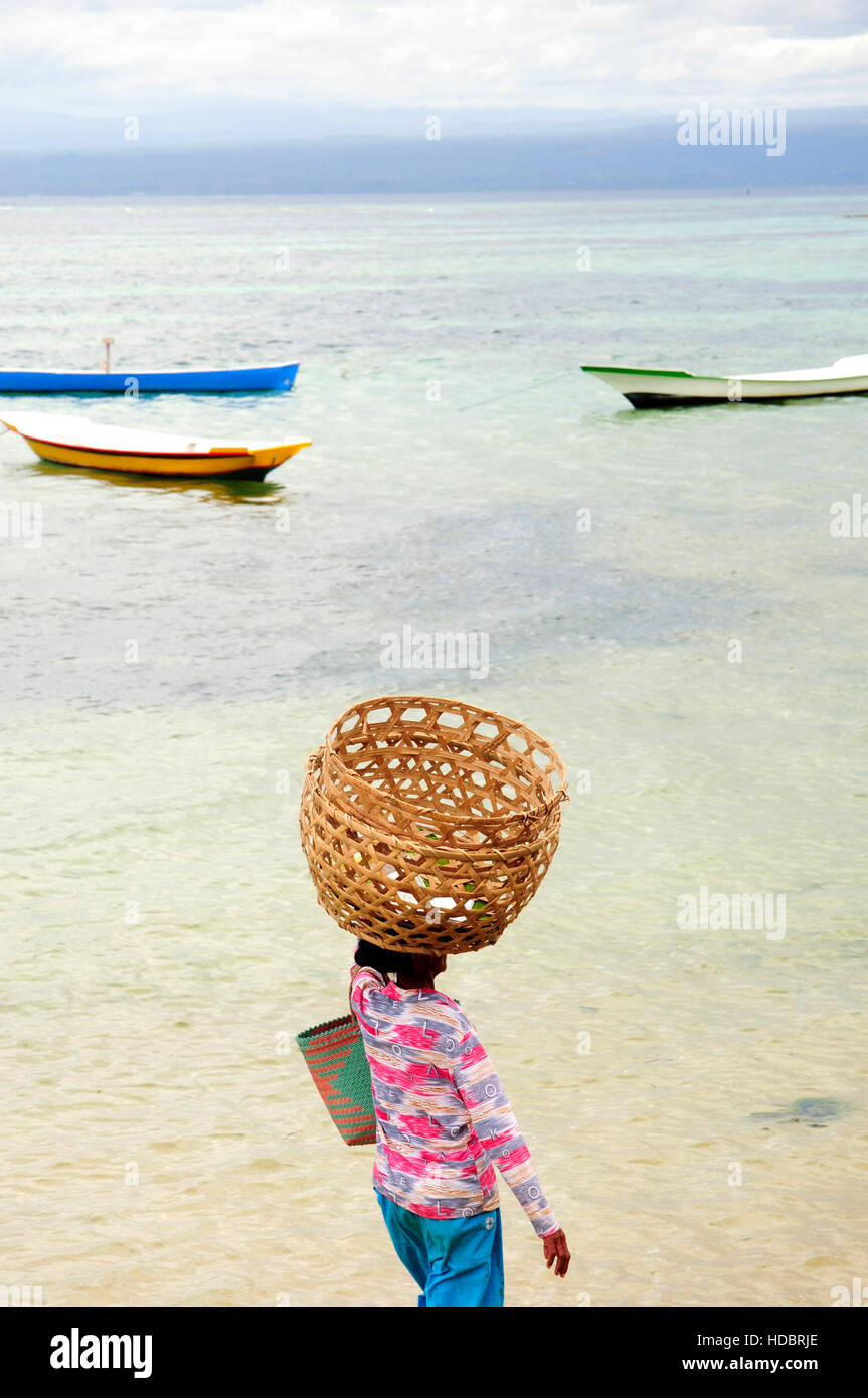 A local woman traverses shallow water in Nusa Lembonagan, Bali, Indonesia, South East Asia Stock Photo