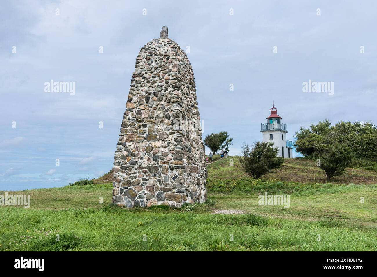 Memorial stone for polar explorer Knud Rasmussen, lighthouse behind, Hundested, Capital Region of Denmark, Denmark Stock Photo