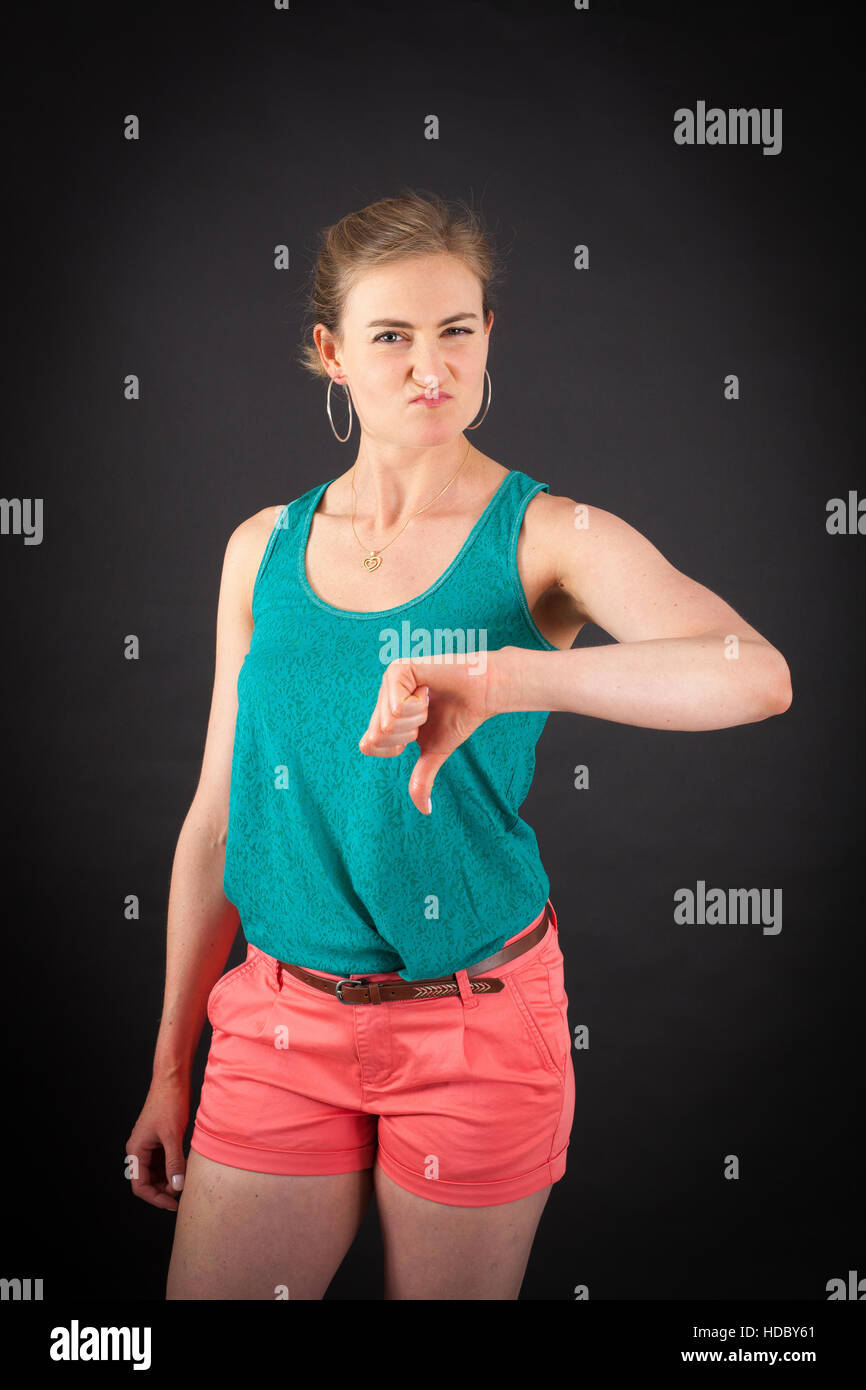 Beautiful woman doing different expressions in different sets of clothes thumbs down Stock