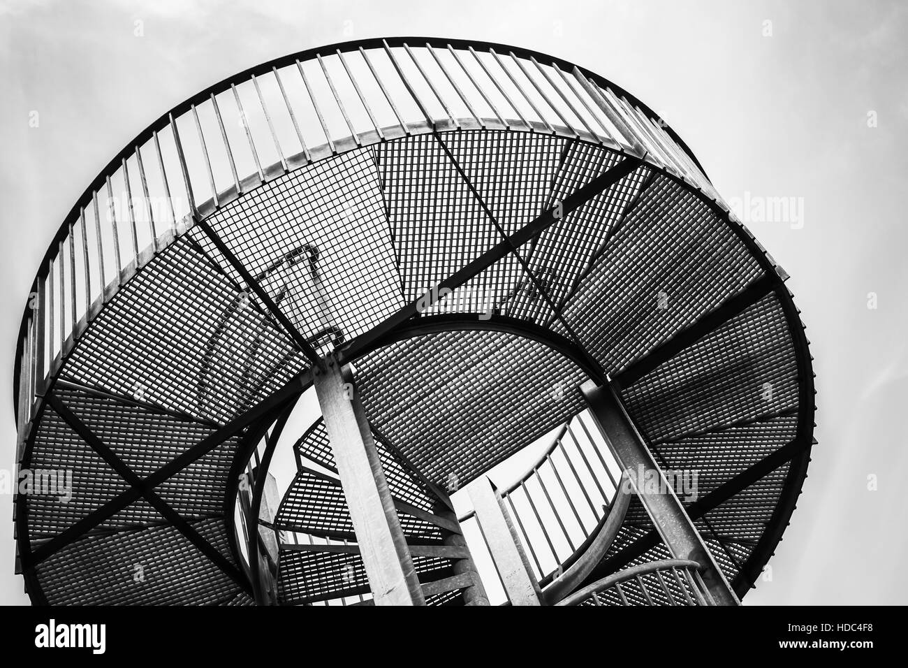 Round metal tower with internal spiral stairway, abstract industrial architecture fragment Stock Photo