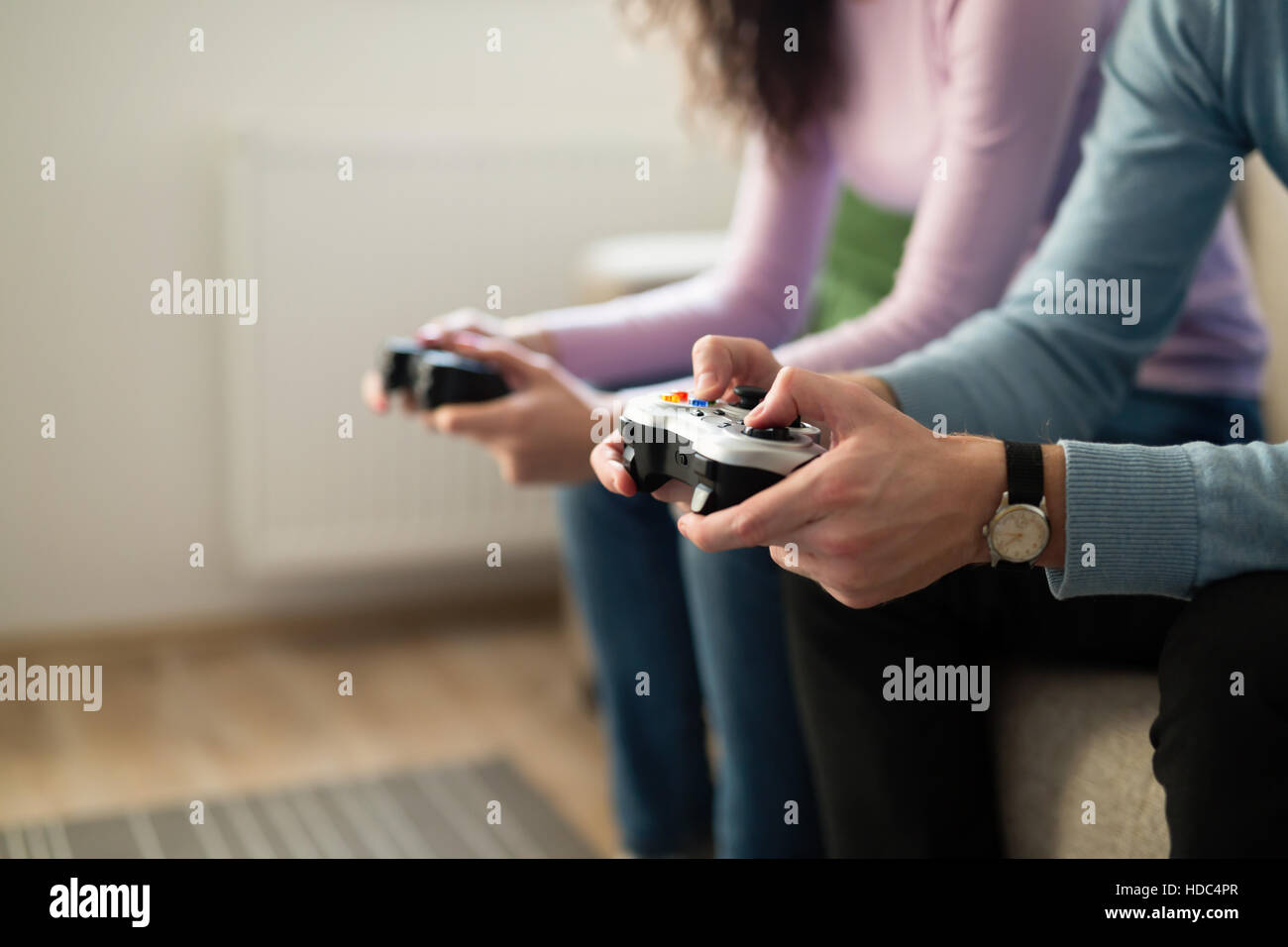 Young people playing video games on console controllers Stock Photo
