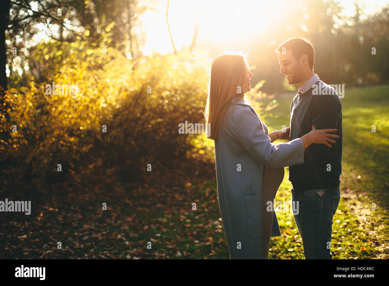 Pregnant woman and man posing at autumn park Stock Photo - Alamy