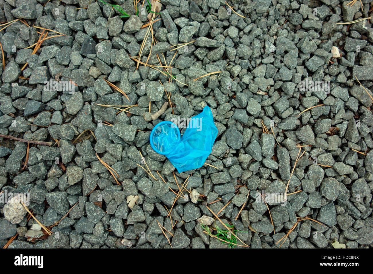 A used condom lying on the ground Stock Photo