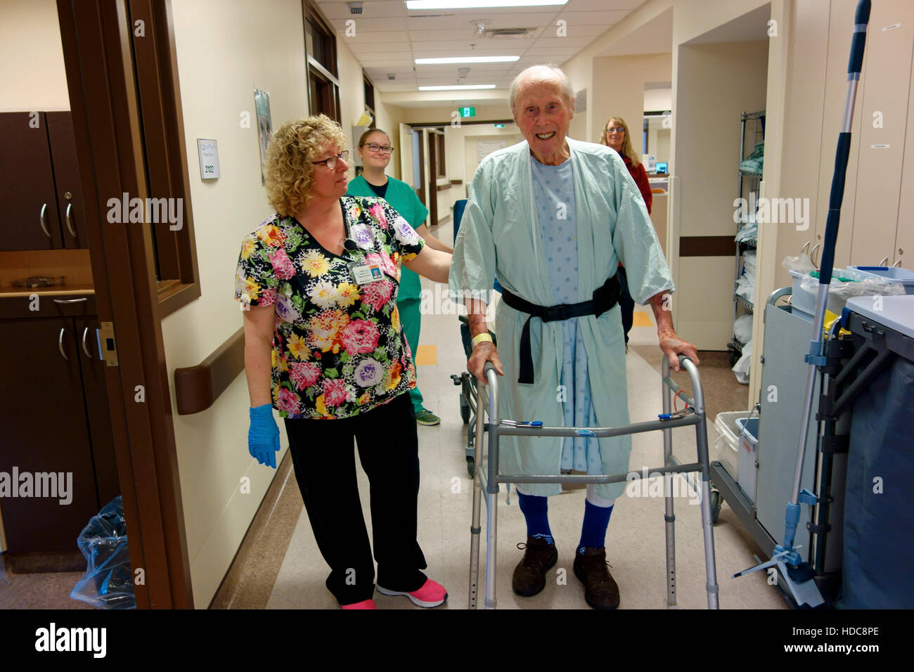 An elderly man walking with assistance in a hospital for recovery Stock Photo