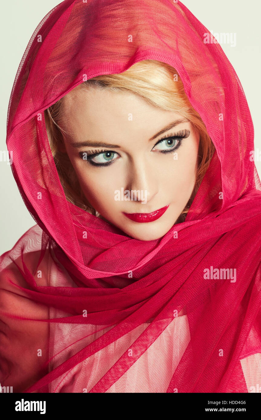 Beautiful woman wearing a red headscarf looking away Stock Photo