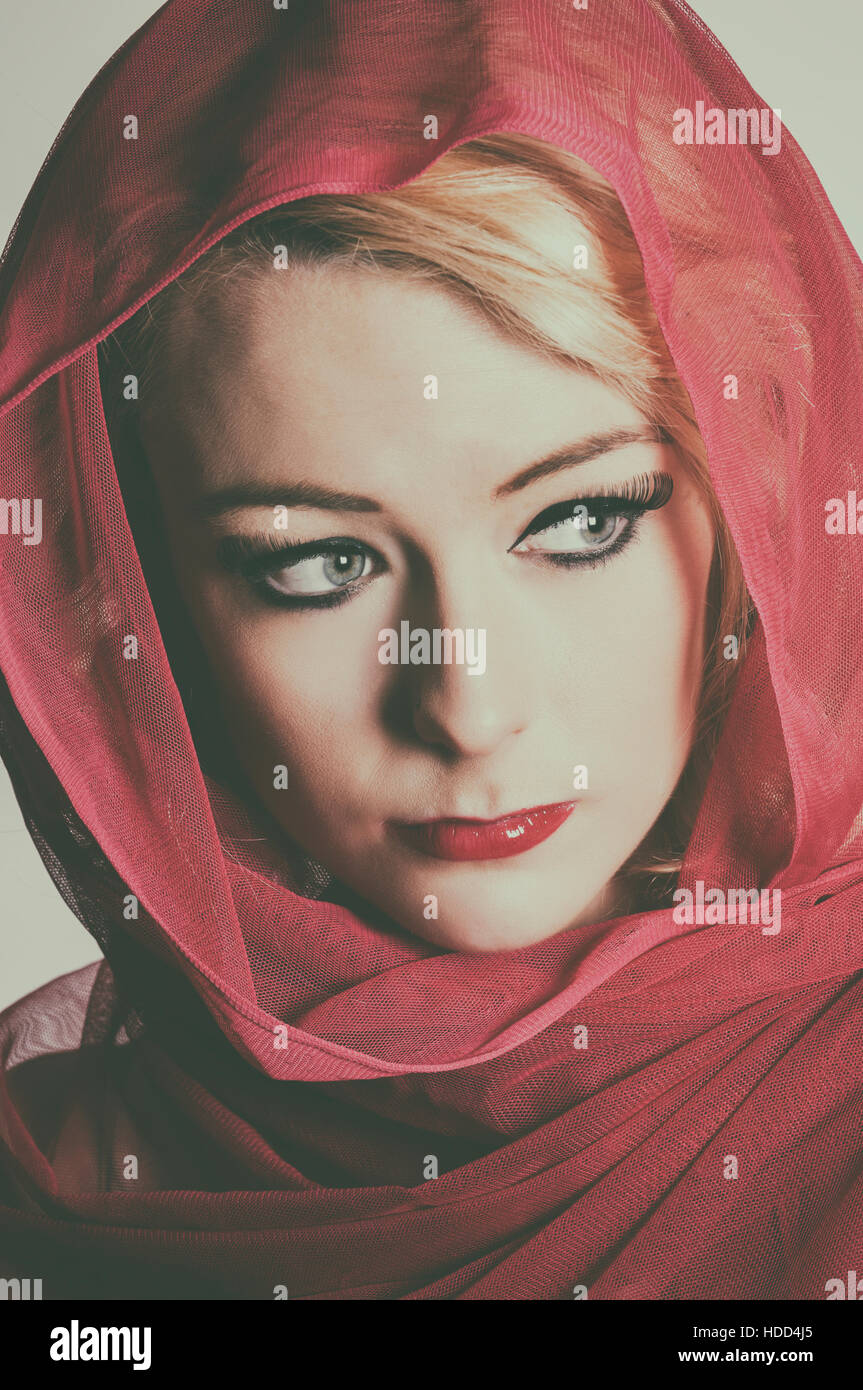 Beautiful woman wearing a red headscarf looking away Stock Photo