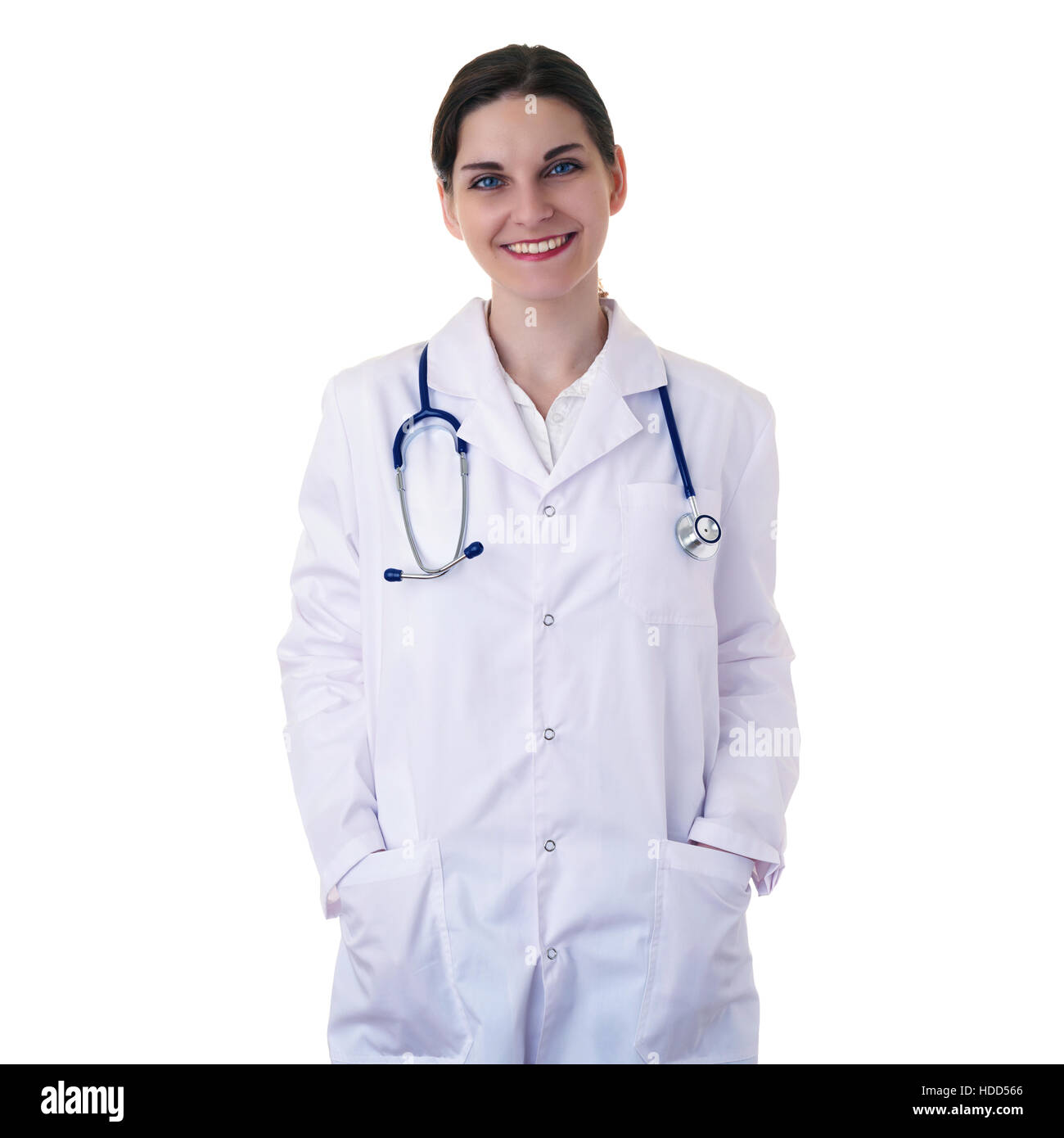 Smiling female doctor assistant in white coat over white isolated background with stethoscope and hands in pockets, healthcare, profession and medicin Stock Photo
