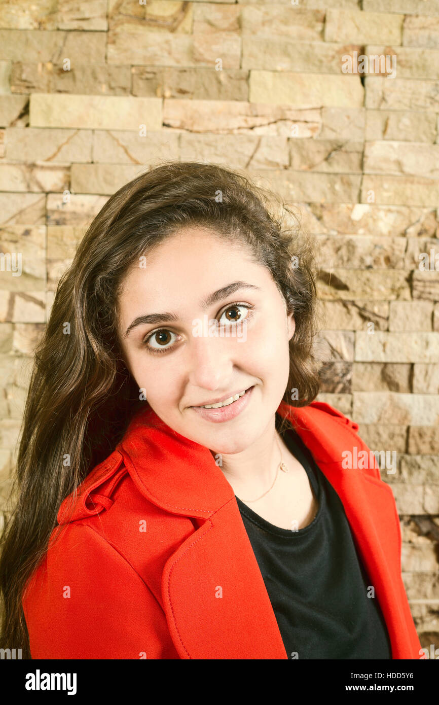 Happy teenage girl wearing a red jacket smiling Stock Photo