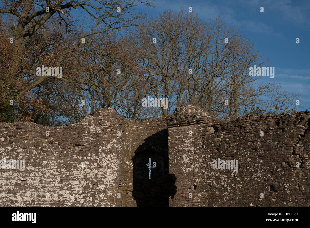 Cross shaped arrow slit on Welsh castle ruin. Stock Photo