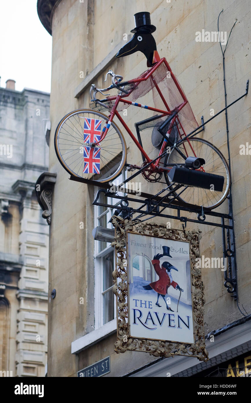 Bicycle  with statue of a Raven on it on a public house wall in Bath Stock Photo