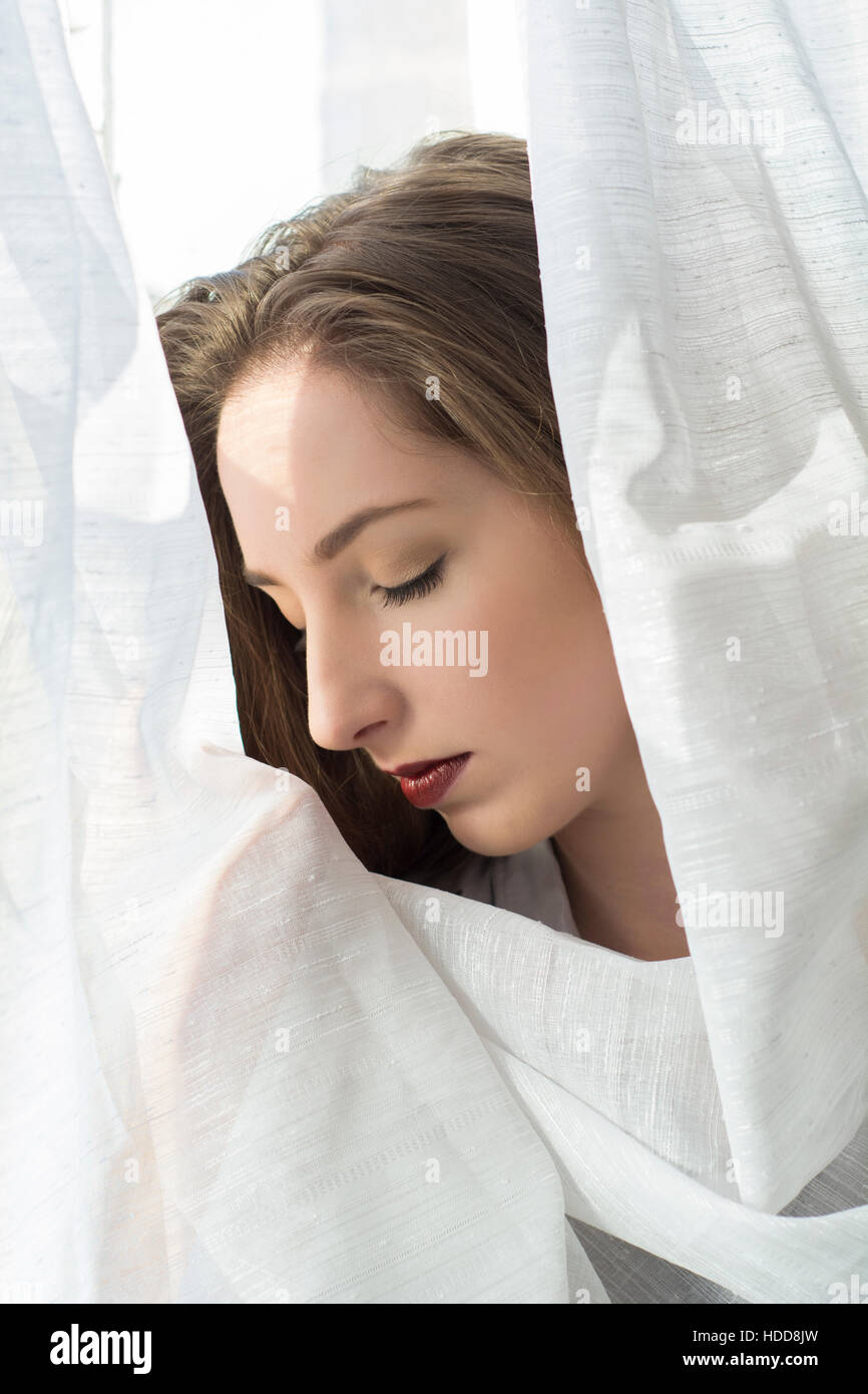 Sad young woman by the window Stock Photo
