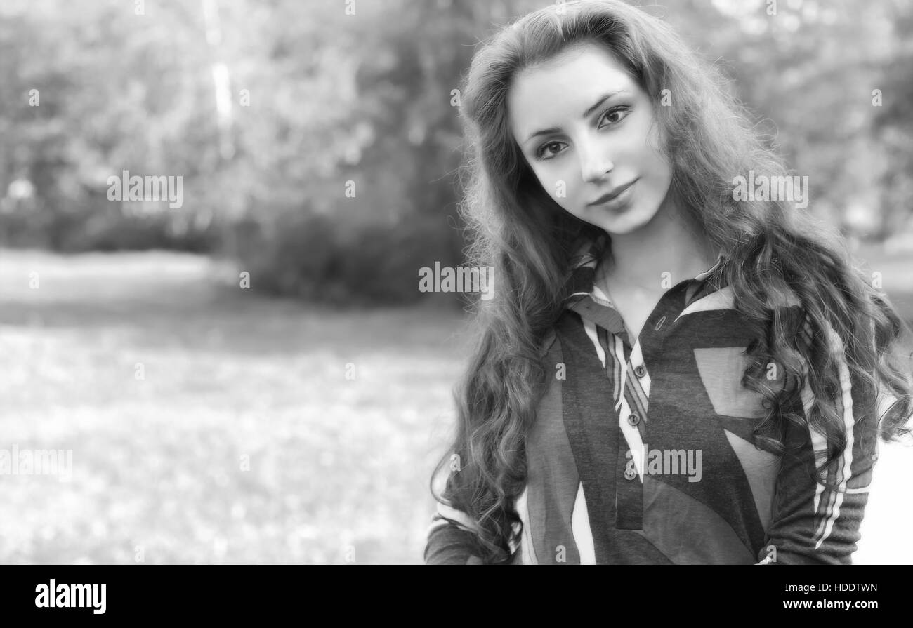 pretty young woman posing on camera in autumn park Stock Photo - Alamy