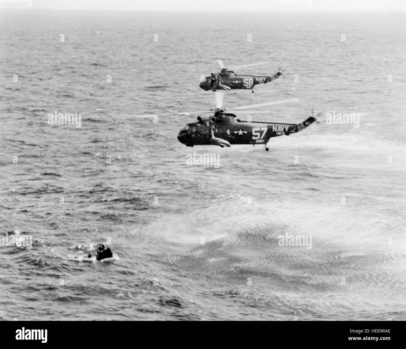 Two USN helicopters hover over the Gemini-Titan 3 spacecraft in the water after a test flight in 1965. Stock Photo