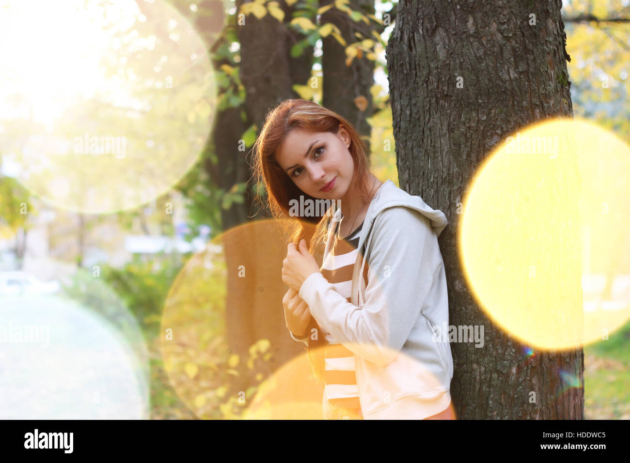 Pretty cute young girl walking in golden autumn park Stock Photo - Alamy