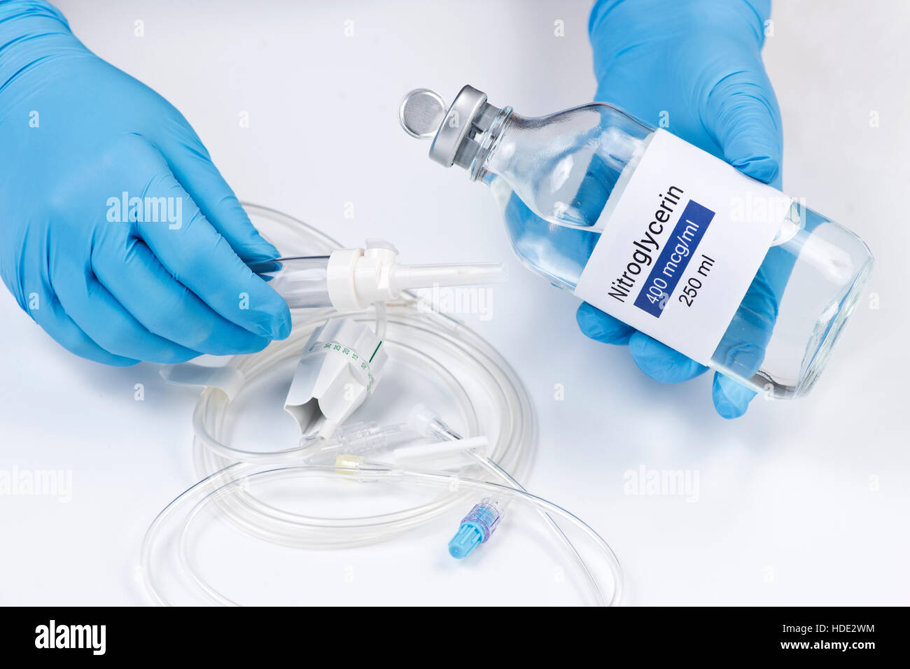 Nitroglycerin bottle held by nurse with iv tubing Stock Photo Alamy