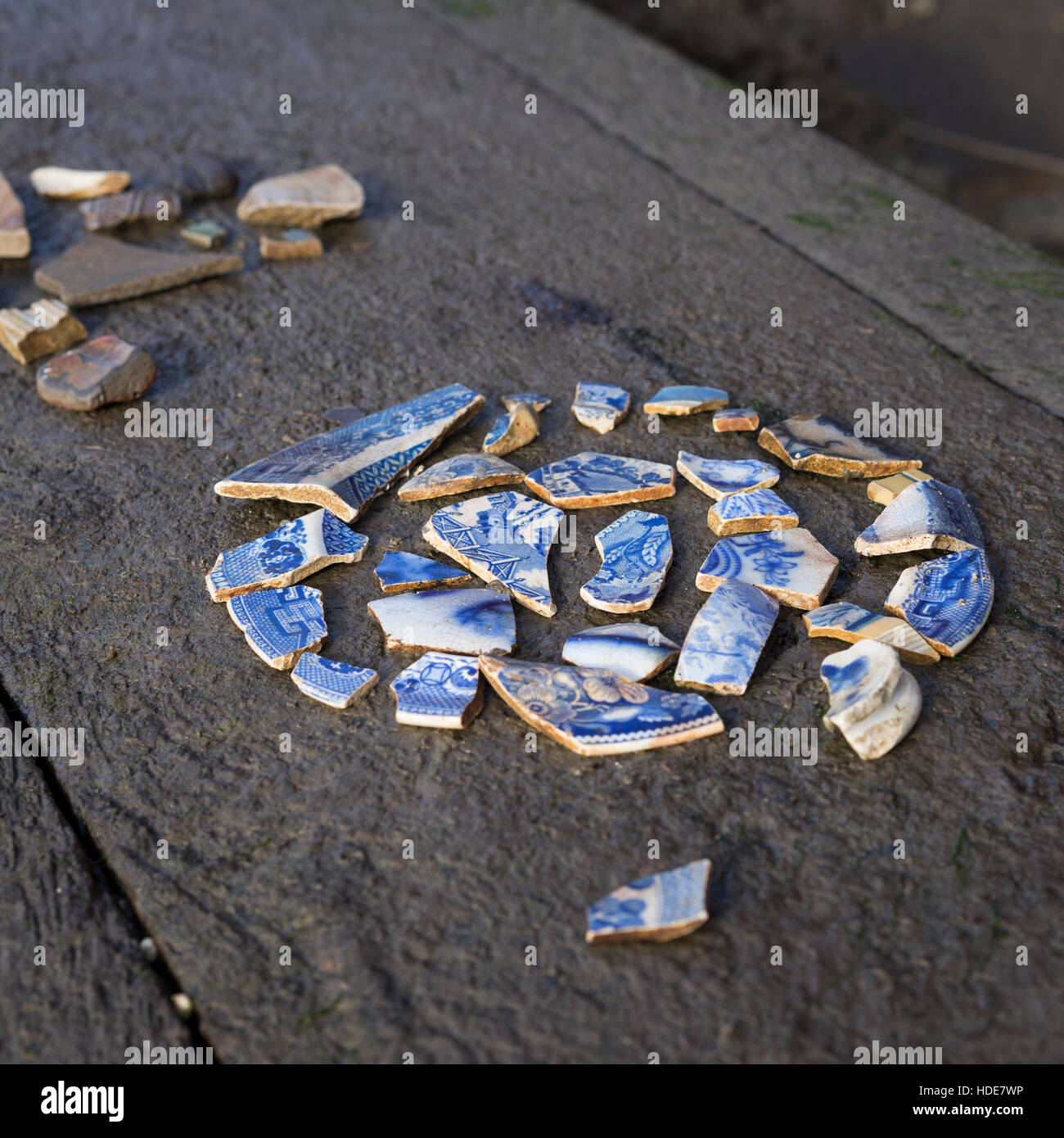 Victorian blue patterned pottery pieces found on the Thames bank foreshore at low tide Stock Photo