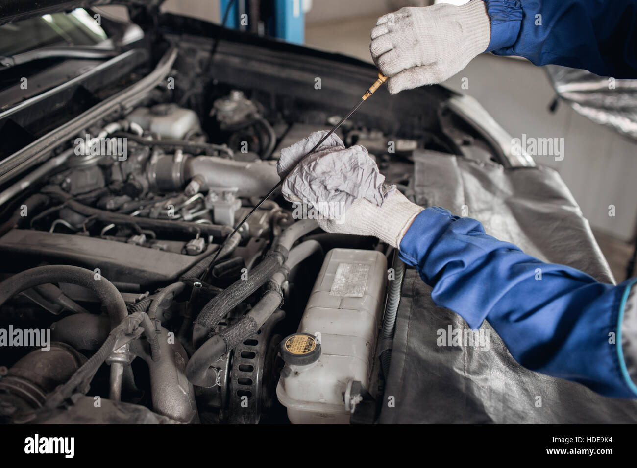 Side view of mechanic checking motor oil in a car with open hood Stock ...