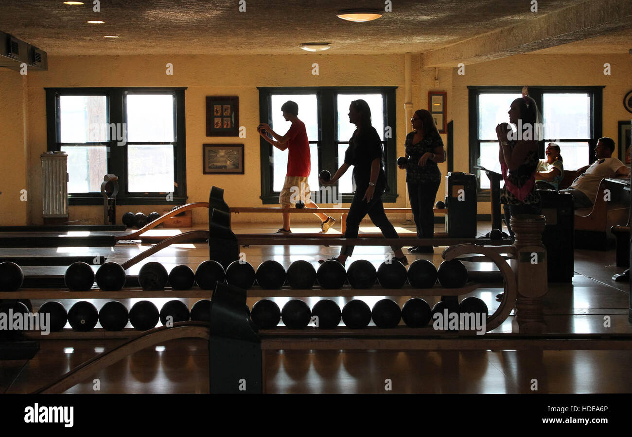 People participate in duckpin bowling. Stock Photo