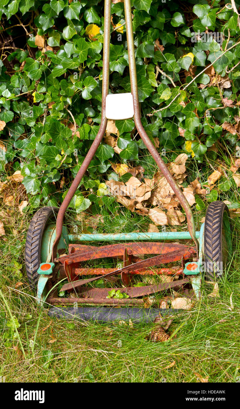 Old, rusty lawnmower in a garden Stock Photo