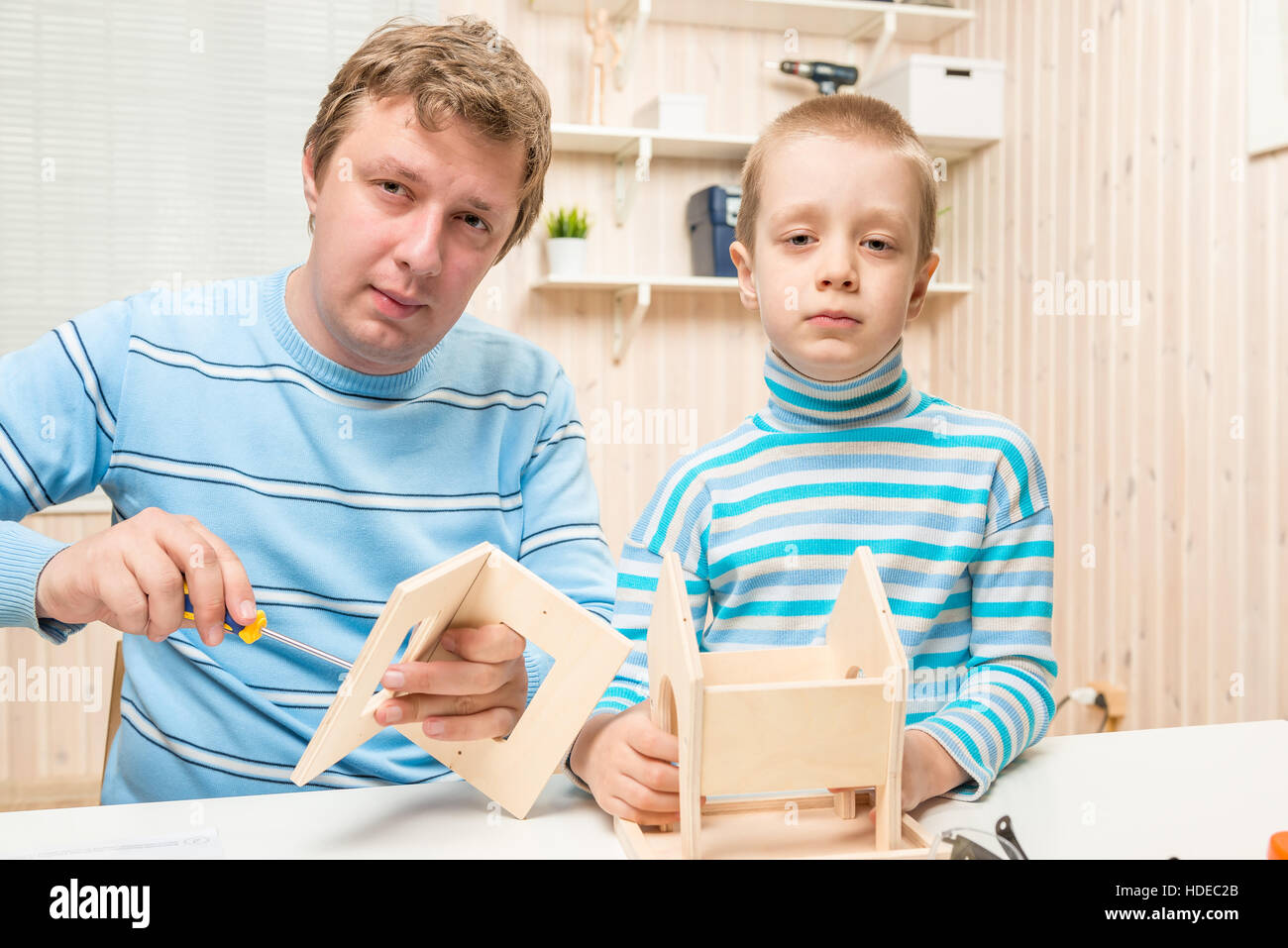 caring father teaches his son to build a bird feeder Stock Photo Alamy