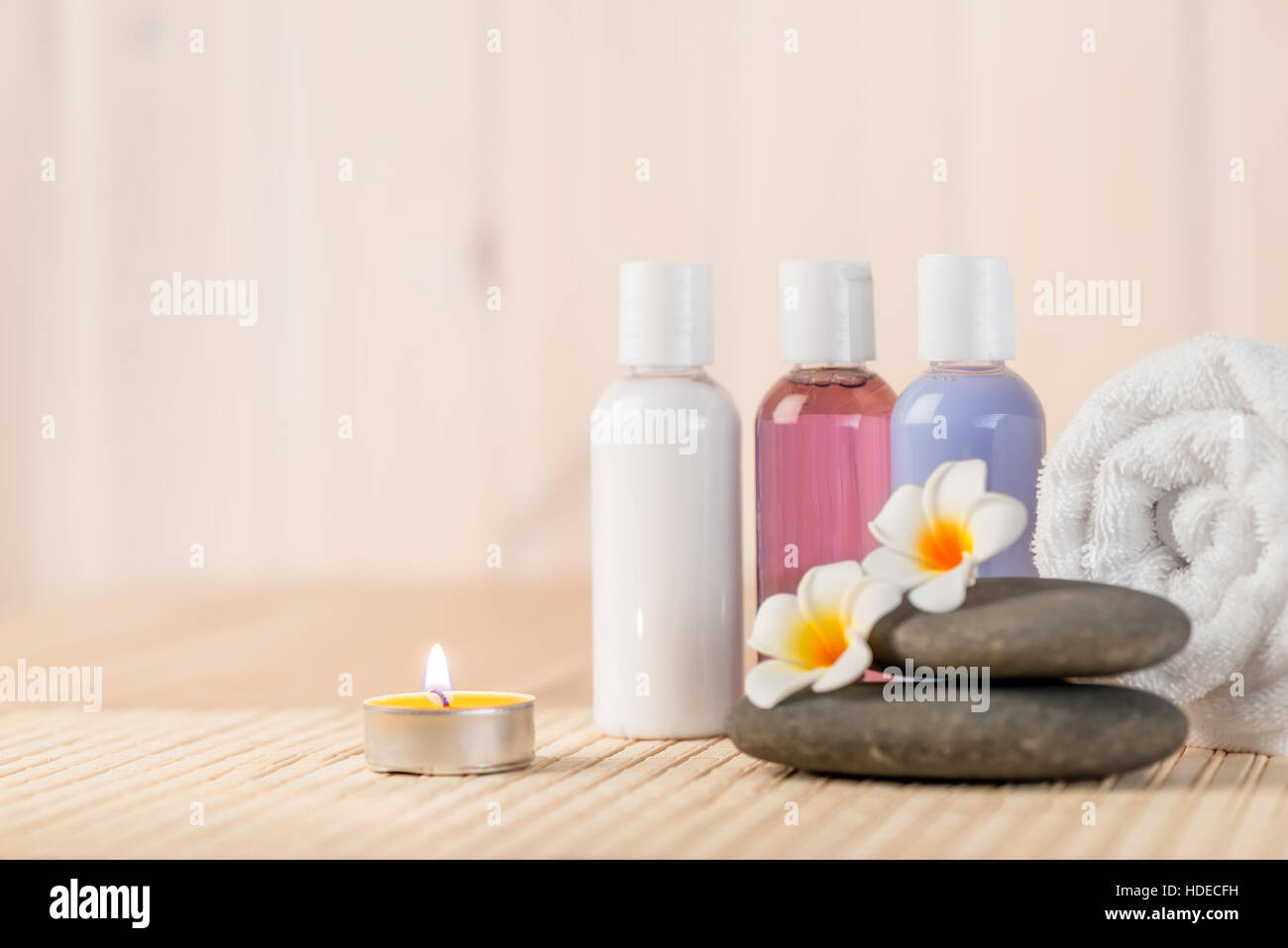 burning candle and beauty products for massage and spa treatments Stock Photo