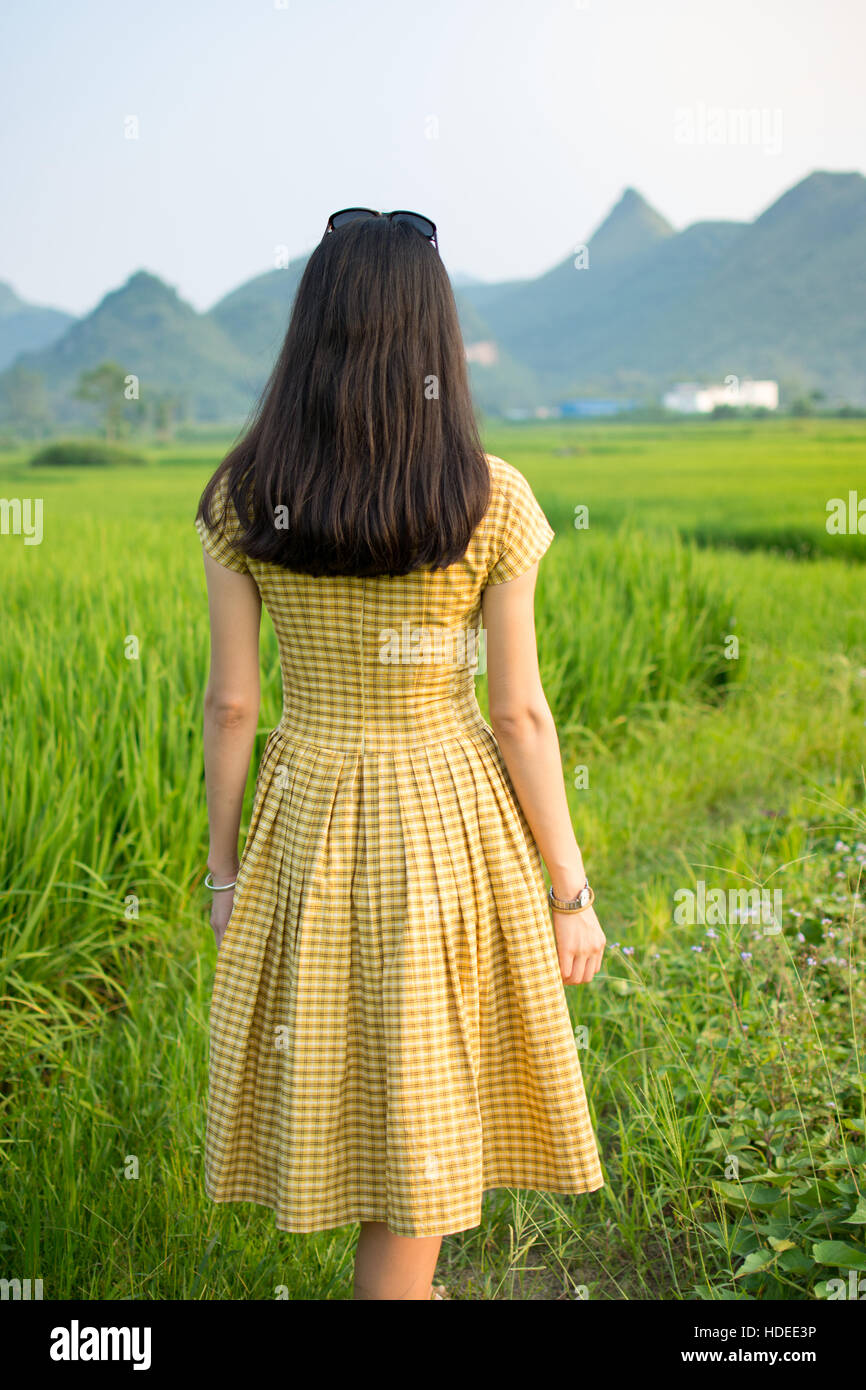 Girl walking in a rice field with karst scenery Stock Photo