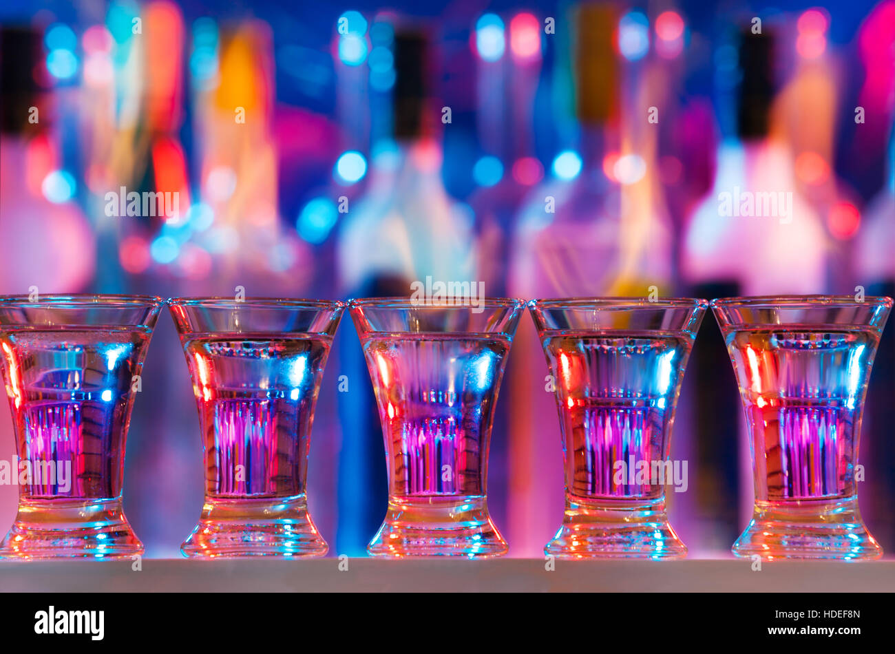 Five burning drinks in shot glasses on bar counter Stock Photo