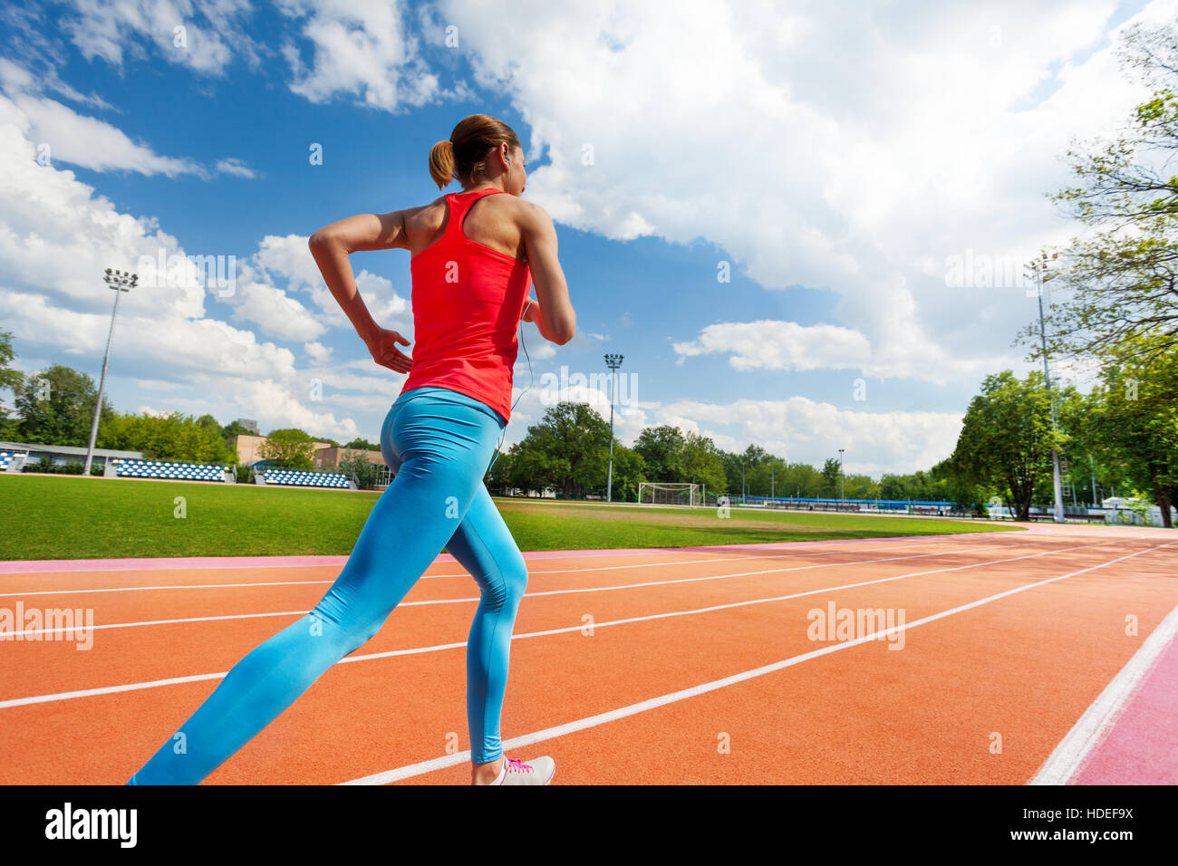 Athletic woman running on stadiums track in summer Stock Photo
