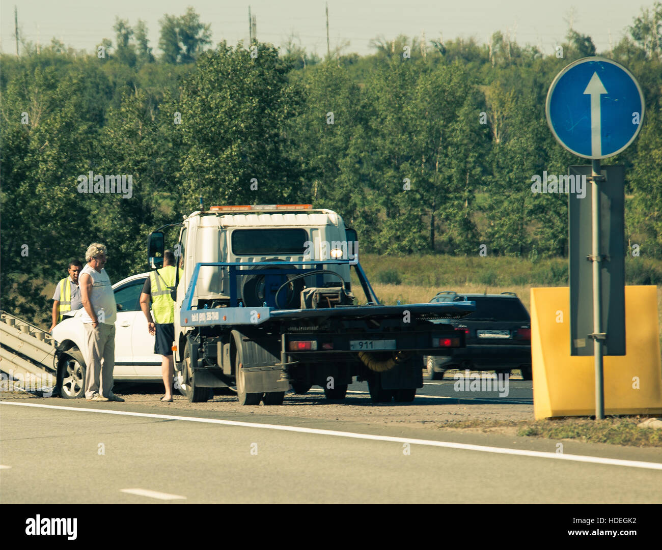 road accident, people and tow-truck near the car, smashed into the bump-stop Stock Photo
