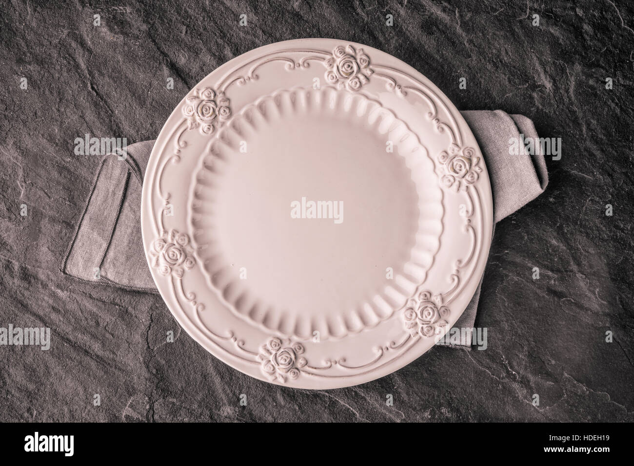 Romantic ceramic plate on the dark stone table top view Stock Photo - Alamy