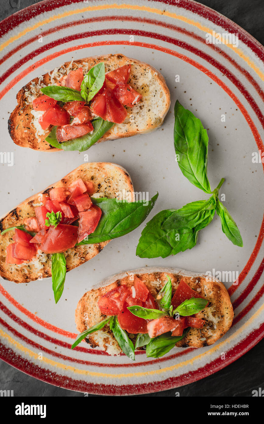 Bruschetta with tomatoes and basil on the colorful ceramic plate Stock Photo
