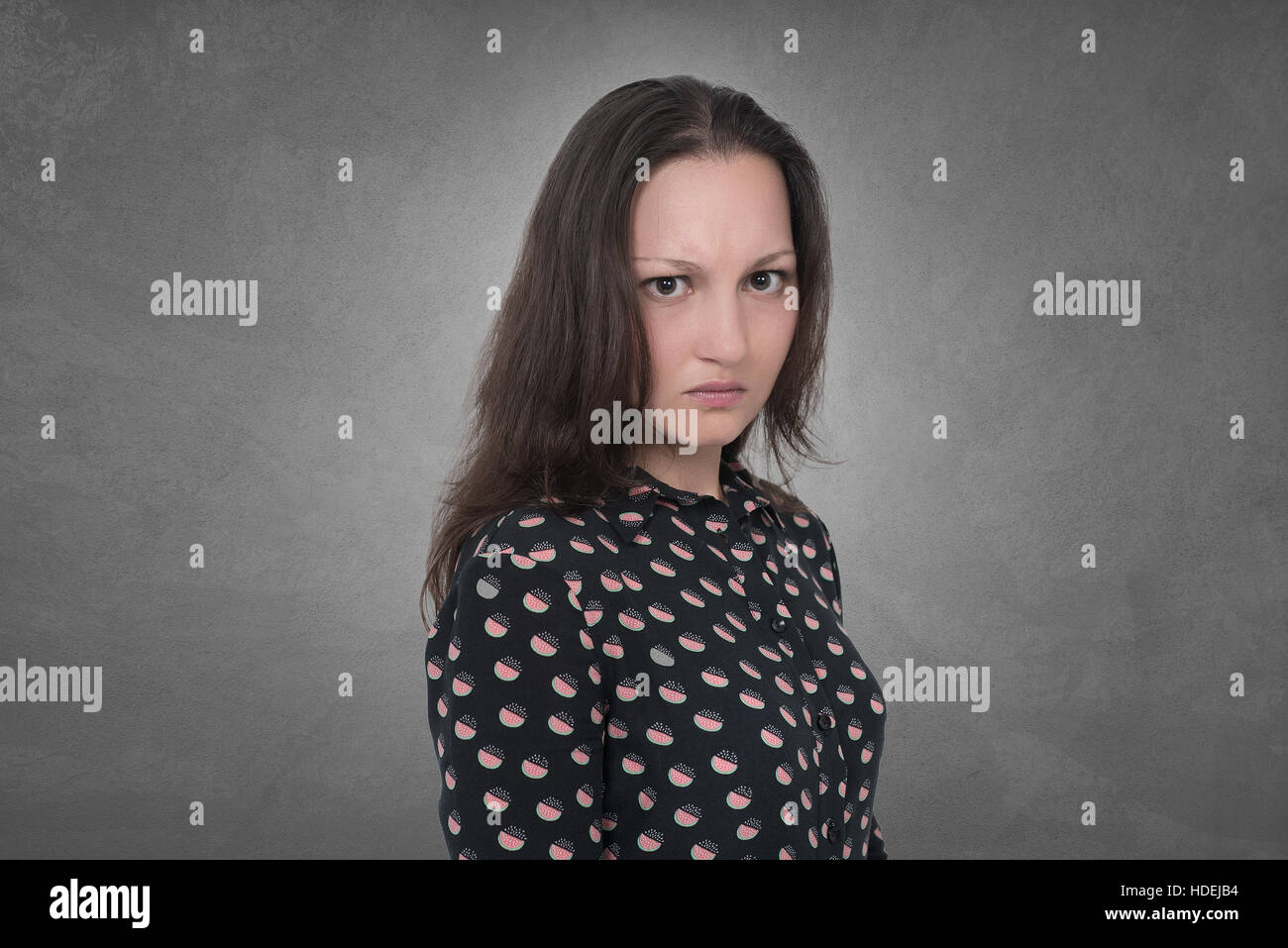 Angry Woman expression on grey wall Stock Photo