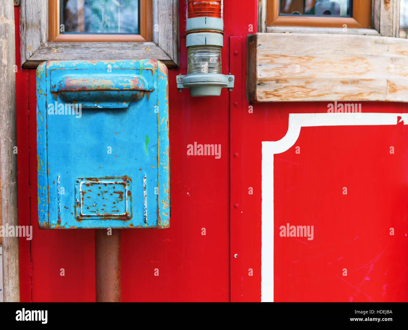 old blue mailbox hanging on red wall. Stock Photo