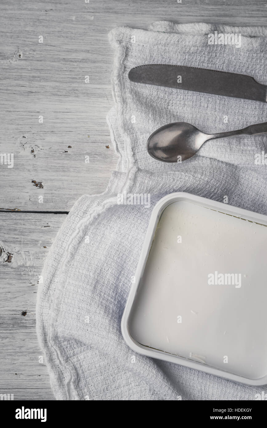 Feta with cutlery and napkin on the white wooden table vertical Stock Photo