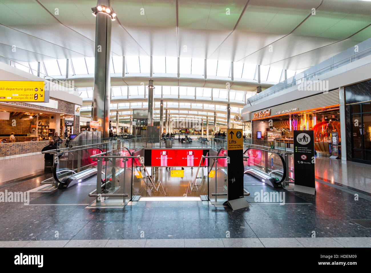England, London, Heathrow airport, Terminal 2. Departure lounge interior. Upper floor, escalator and Yo Sushi restaurant and food court area. Stock Photo
