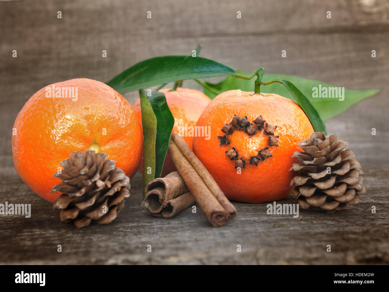 tangerine with cloves in the shape of a heart and cinnamon on wooden background Stock Photo