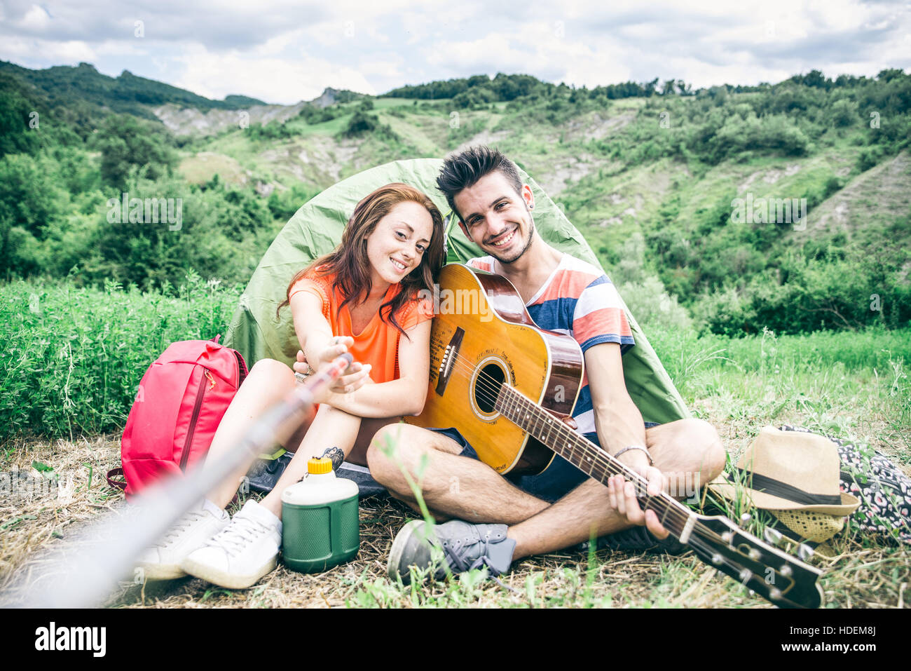Couple taking a selfie in a campsite Young people having fun while