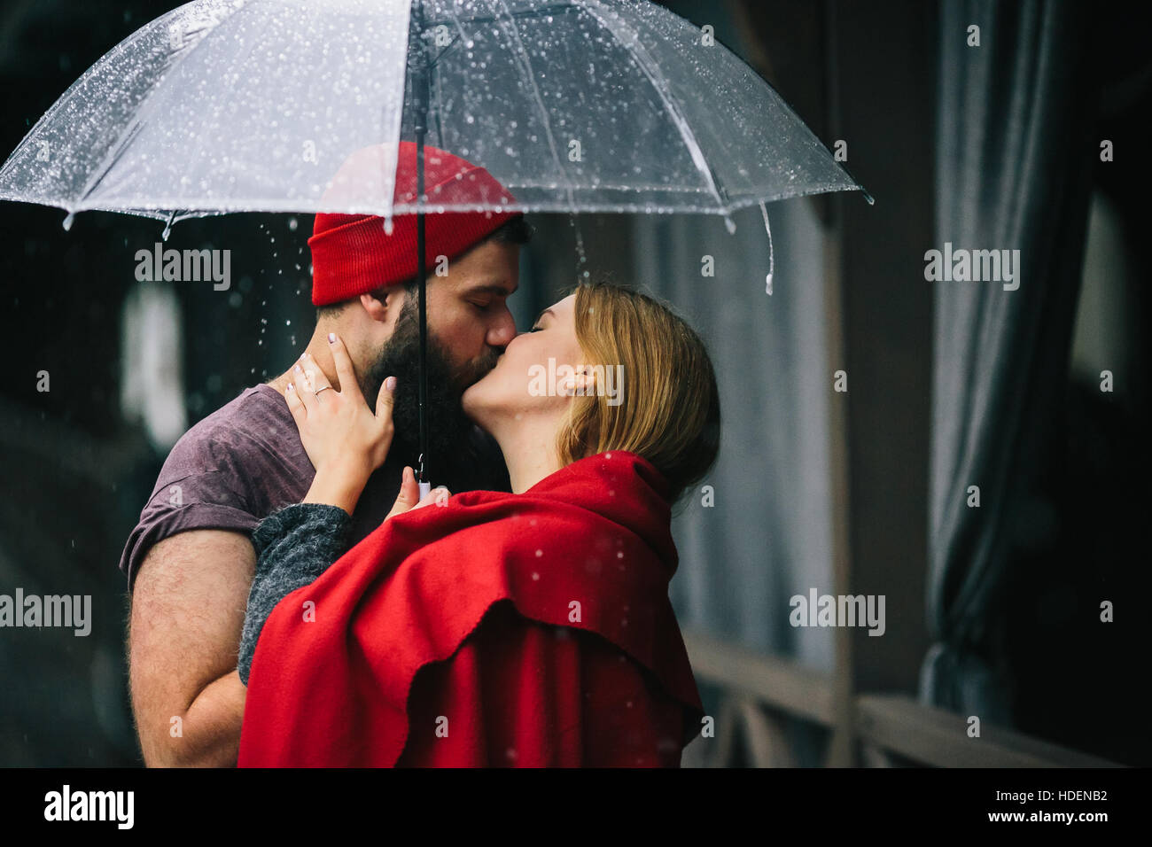 guy and the girl kissing under an umbrella Stock Photo - Alamy
