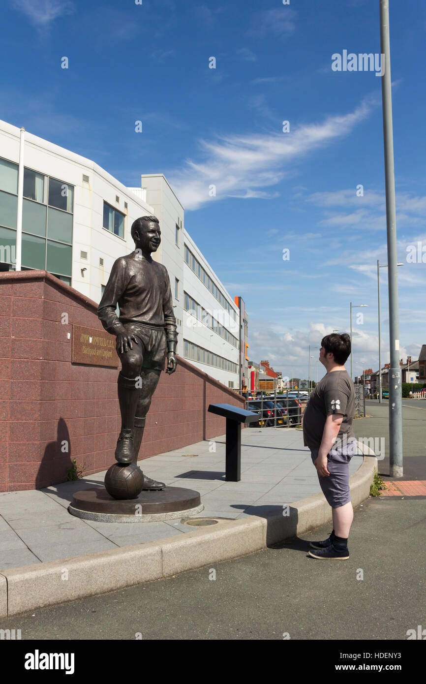 Young man admiring the statue of Jimmy Armfield, former player and captain of Blackpool Football Club. Stock Photo