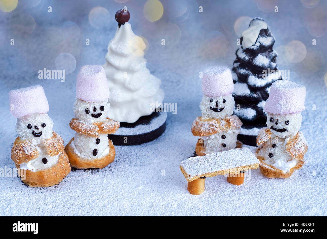 Little cakes snowmen and chocolate trees in powdered sugar Stock Photo