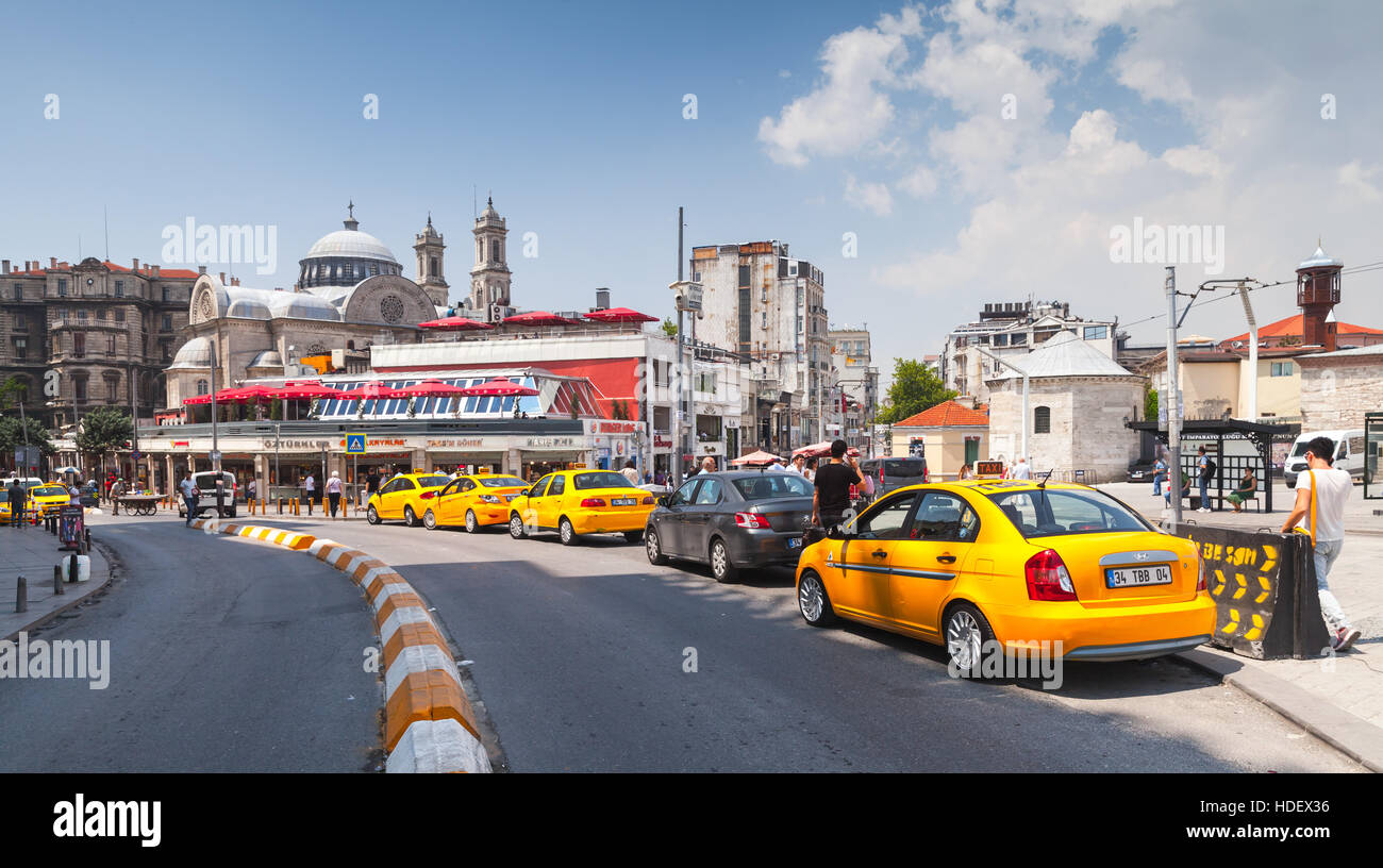 Istanbul, Turkey - July 1, 2016: Taxi drivers waiting passengers near yellow cars on Taksim square. Cityscape of Istanbul Stock Photo