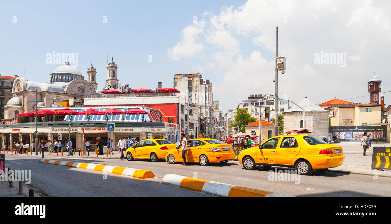 Istanbul, Turkey - July 1, 2016: Taxi drivers and passengers near yellow cars on Taksim square. Cityscape of modern Istanbul city Stock Photo