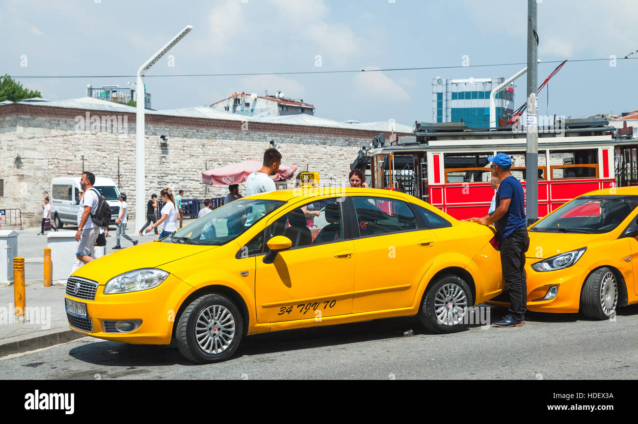 Istanbul, Turkey - July 1, 2016: Taxi drivers and passengers near yellow cars on Taksim square. Cityscape of Istanbul city Stock Photo