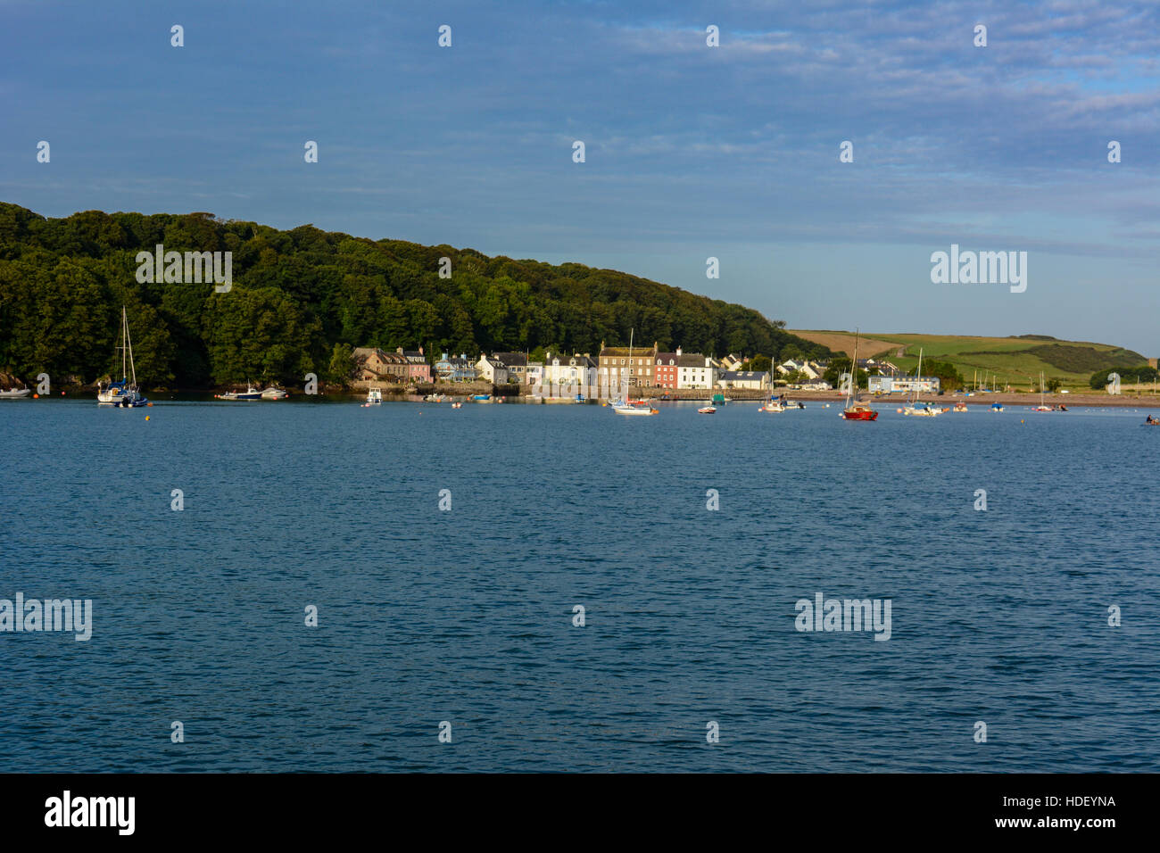 Boats anchored on a blue rippled sea in early morning summer sun at Dale, Pembrokeshire. Stock Photo