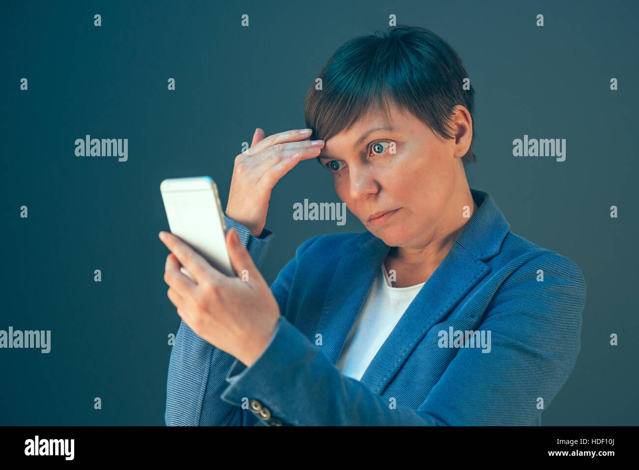 Businesswoman taking selfie portrait with mobile phone before important business meeting in office Stock Photo