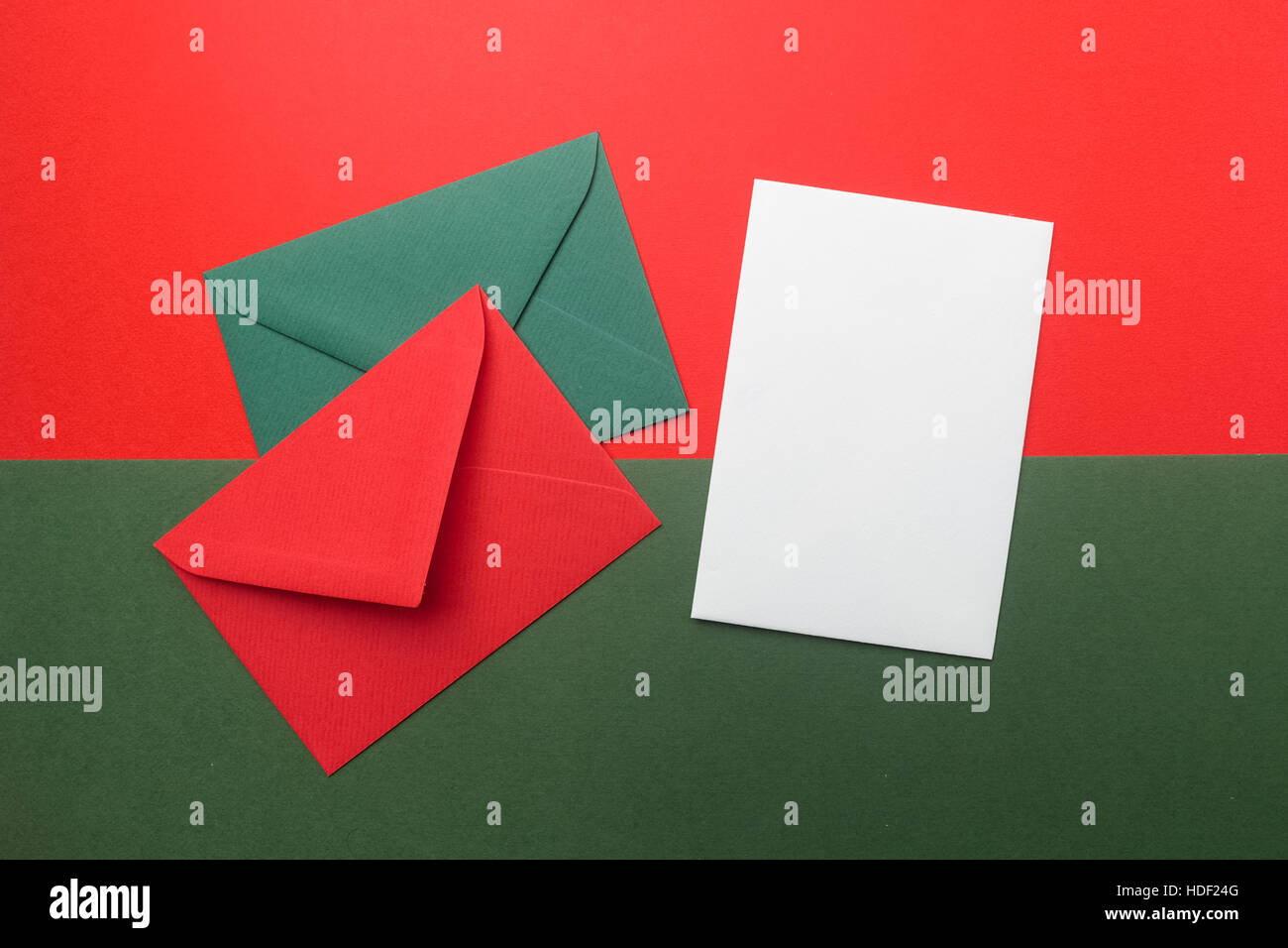 Red and green envelopes on christmas holiday background flat lay stock